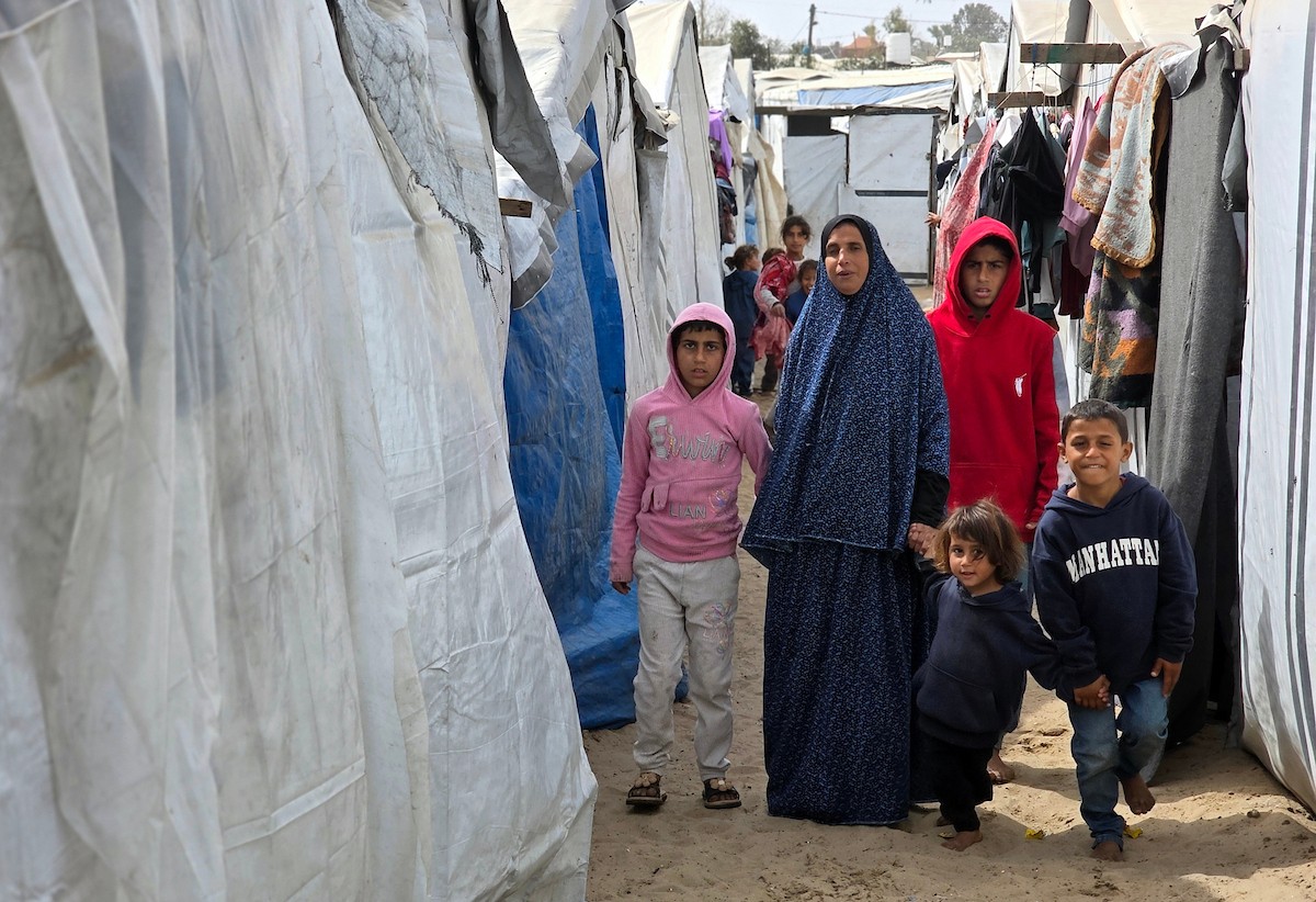 هالة عوض (48 عاما) كفيفة فقدت زوجها في هجوم إسرائيلي، تعيش مع أطفالها السبعة في خيمة مؤقتة غرب خان يونس، وتعيلهم بمفردها رغم إعاقتها البصرية. تصوير: طارق محمد