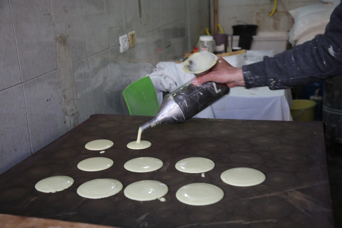 فلسطينيون يتسوقون استعدادًا للإفطار في أول أيام شهر رمضان المبارك، في مدينة نابلس بالضفة الغربية، 18 فبراير/شباط 2026. صورة: محمد ناصر