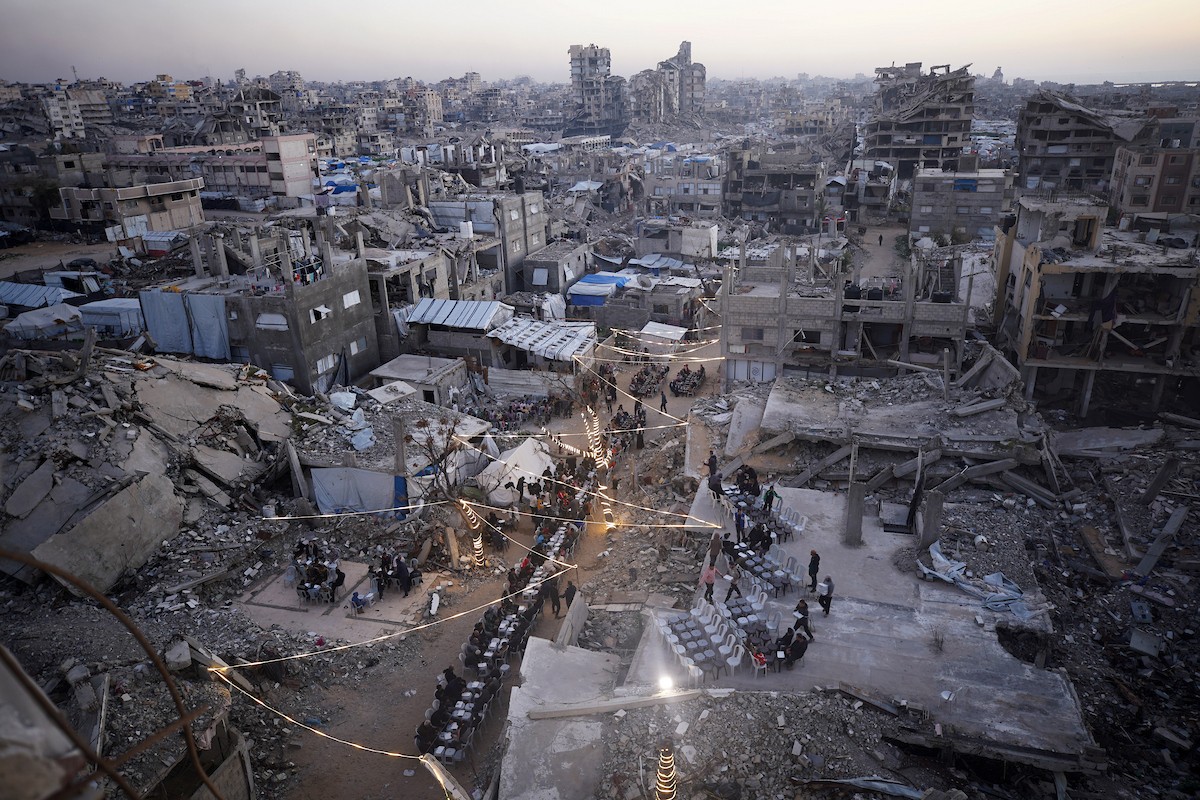 يتجمع الفلسطينيون بين المنازل المدمرة لتناول وجبة الإفطار معًا خلال شهر رمضان المبارك في شمال قطاع غزة، 22 فبراير/شباط 2026. صورة: عمر أشتوي