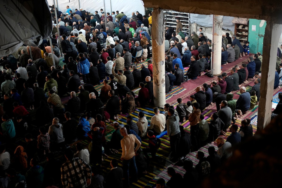 فلسطينيون يؤدون صلاة التراويح في أول ليلة من شهر رمضان على أنقاض مسجد الكنز المدمر في مدينة غزة، في 17 فبراير/شباط 2026. وكان مفتي القدس والأراضي الفلسطينية قد أعلن أن يوم الأربعاء 18 فبراير/شباط 2026 هو أول أيام رمضان. (صورة: عمر أشتوي)
