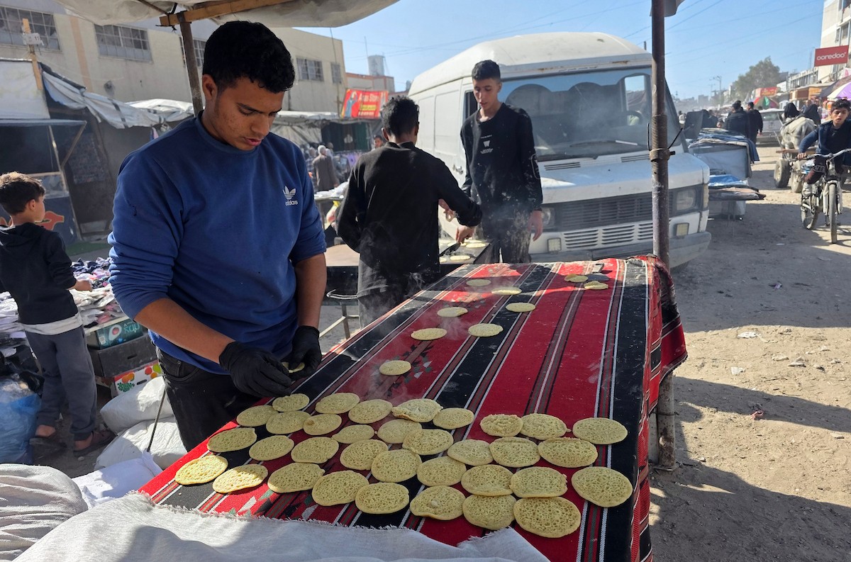 بائعٌ يُعدّ حلوى القطايف الشهيرة بالطرق التقليدية احتفالاً بشهر رمضان المبارك. ورغم الظروف المعيشية الصعبة، يواصل السكان شراء هذه الحلوى التقليدية. خان يونس، جنوب قطاع غزة، ٢٢ فبراير ٢٠٢٦. تصوير: طارق محمد