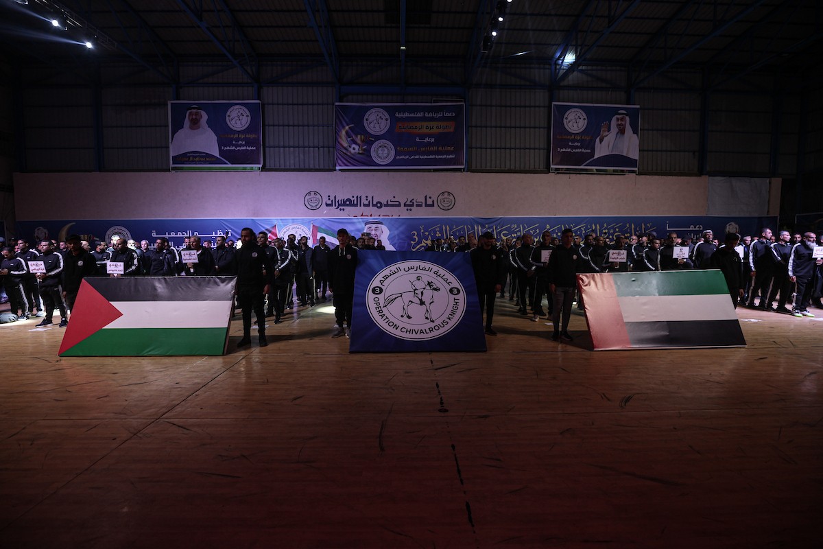 لاعبون فلسطينيون من فريقي النصيرات ورفح يتنافسون خلال مباراة كرة قدم على ملعب نادي خدمات النصيرات، ضمن بطولة غزة الرمضانية، بحضور حشد جماهيري كبير، في مخيم النصيرات بوسط قطاع غزة، بتاريخ 21 فبراير/شباط 2026. تصوير: معز صالحي / apaimages