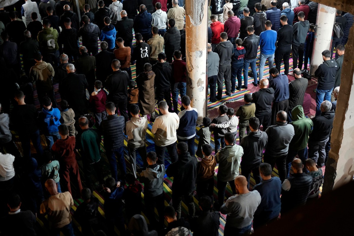 فلسطينيون يؤدون صلاة التراويح في أول ليلة من شهر رمضان على أنقاض مسجد الكنز المدمر في مدينة غزة، في 17 فبراير/شباط 2026. وكان مفتي القدس والأراضي الفلسطينية قد أعلن أن يوم الأربعاء 18 فبراير/شباط 2026 هو أول أيام رمضان. (صورة: عمر أشتوي)