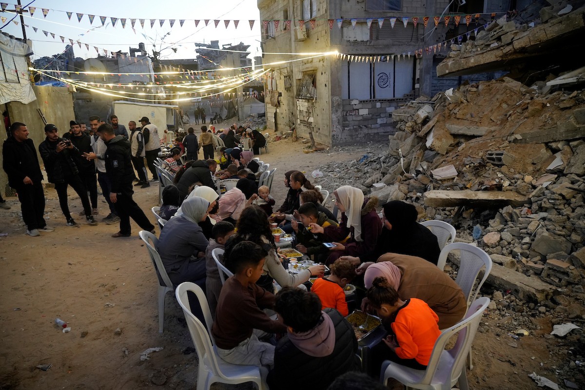 يتجمع الفلسطينيون بين المنازل المدمرة لتناول وجبة الإفطار معًا خلال شهر رمضان المبارك في شمال قطاع غزة، 22 فبراير/شباط 2026. صورة: عمر أشتوي