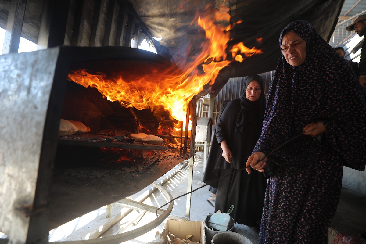 مجموعة من النساء يعملن داخل مخبز أُنشئ في مخيم اليرموك للاجئين بمدينة غزة، ضمن مبادرة إنسانية بالشراكة مع اللجنة الدولية للصليب الأحمر. تهدف المبادرة إلى تخفيف الأعباء المعيشية عن النساء النازحات، لا سيما خلال شهر رمضان. مدينة غزة، 25 فبراير/شباط 2026. تصوير: عمر أشتوي