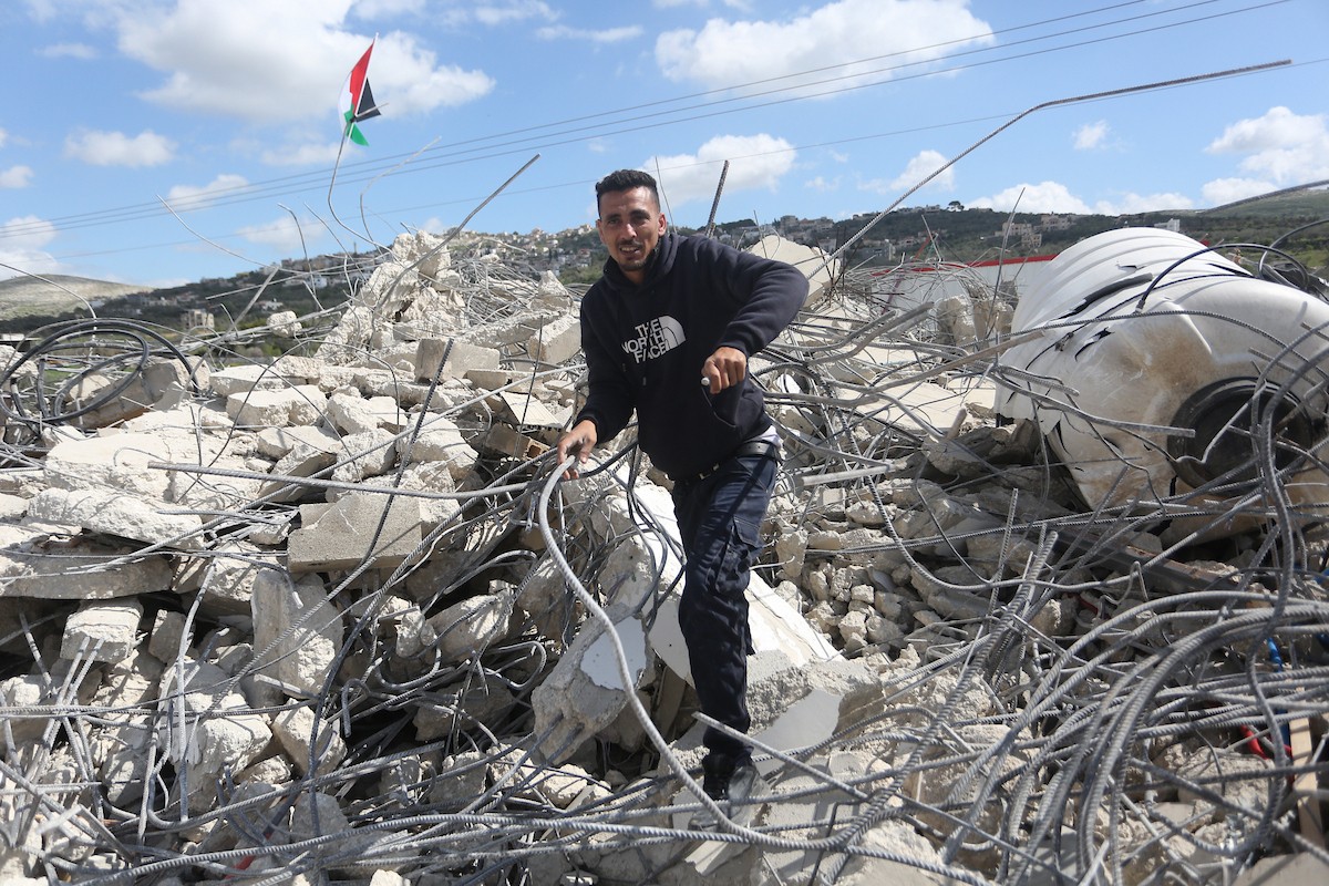 فلسطينيون يتفقدون منزلاً بعد هدمه على يد قوات الجيش الإسرائيلي في قرية عنزة، جنوب جنين بالضفة الغربية. ٢٥ فبراير ٢٠٢٦. صورة: محمد ناصر