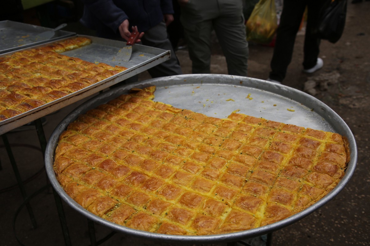 فلسطينيون يتسوقون استعدادًا للإفطار في أول أيام شهر رمضان المبارك، في مدينة نابلس بالضفة الغربية، 18 فبراير/شباط 2026. صورة: محمد ناصر