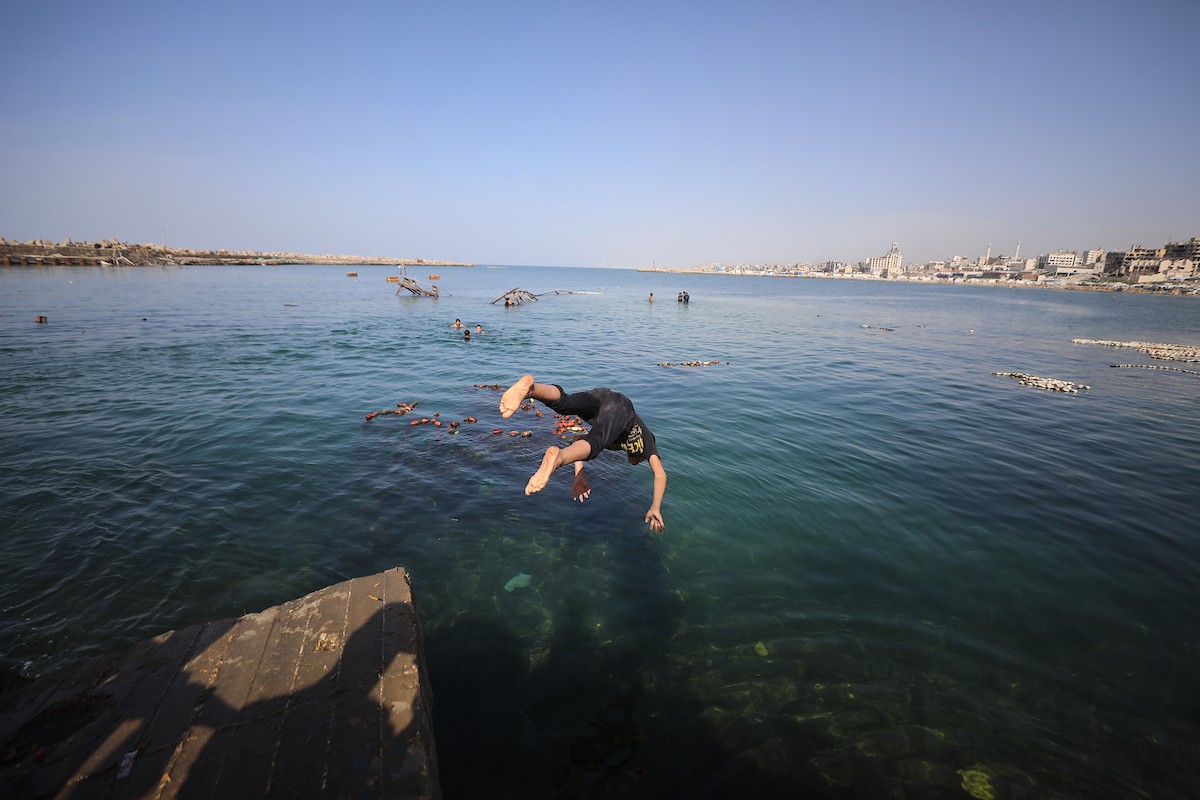 يسبح أطفال قرب ميناء غزة المدمر، في مشهد يعكس تمسكهم بلحظات الفرح رغم الدمار المحيط بهم. يُعدّ البحر في غزة المتنفس الوحيد لسكانها الذين يواجهون آثار الحرب والنزوح، والذين يعيشون في خيام تفتقر لأبسط مقومات الحياة، ١٢ فبراير ٢٠٢٦. تصوير: عمر أشتوي
