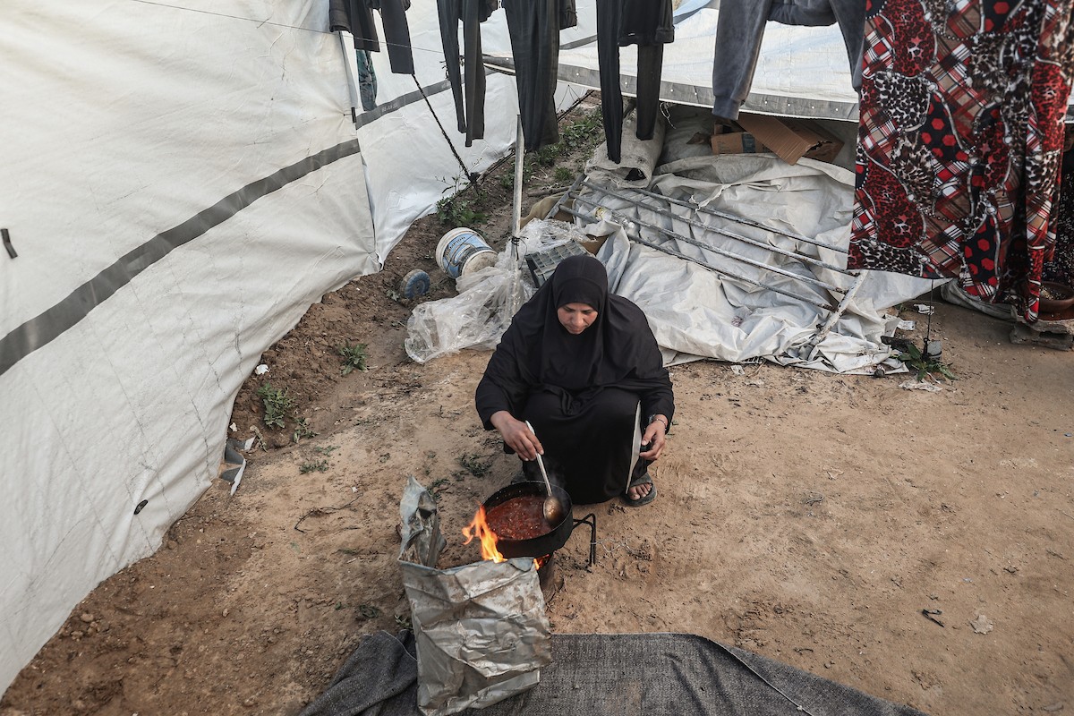 عائلة فلسطينية نازحة تتناول فطورها خلال شهر رمضان داخل خيمة متداعية في مخيم النصيرات للاجئين وسط قطاع غزة. تواجه العائلات النازحة ظروفًا معيشية قاسية نتيجة الحرب، مع انعدام الدخل ونقص حاد في المساعدات الإنسانية، 26 فبراير/شباط 2026. تصوير: معز صالحي