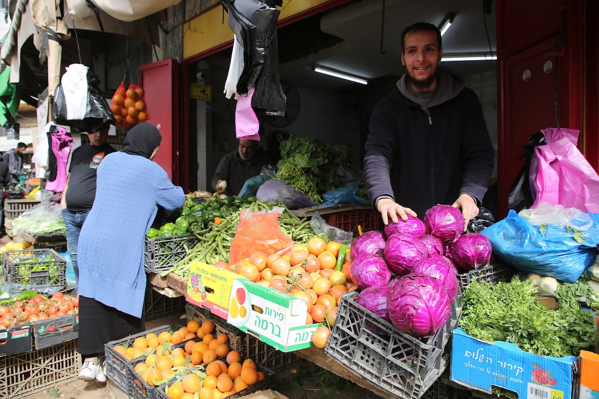 فلسطينيون يتسوقون استعدادًا للإفطار في أول أيام شهر رمضان المبارك، في مدينة نابلس بالضفة الغربية، 18 فبراير/شباط 2026. صورة: محمد ناصر