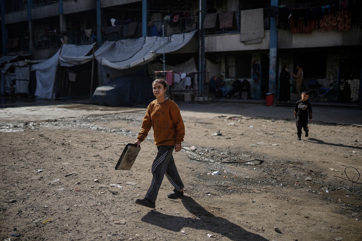 فلسطينيون بينهم أطفال ونساء يتلقون مساعدات غذائية وزعتها منظمات خيرية في أحد مراكز الإيواء بمدينة غزة، وسط أزمة غذائية مستمرة ناجمة عن محدودية المساعدات الإنسانية والظروف الإنسانية المتردية التي يواجهها النازحون، ١٢ فبراير/شباط ٢٠٢٦. تصوير: عمر أشتوي