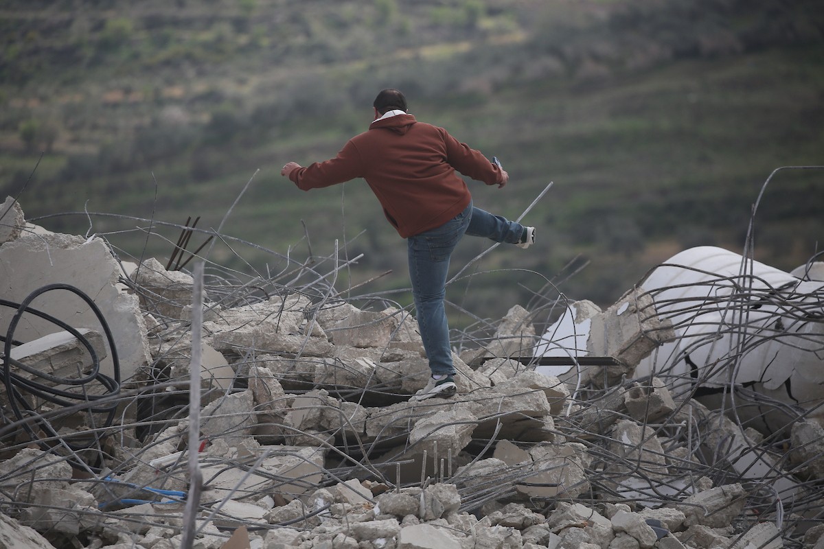 فلسطينيون يتفقدون منزلاً بعد هدمه على يد قوات الجيش الإسرائيلي في قرية عنزة، جنوب جنين بالضفة الغربية. ٢٥ فبراير ٢٠٢٦. صورة: محمد ناصر