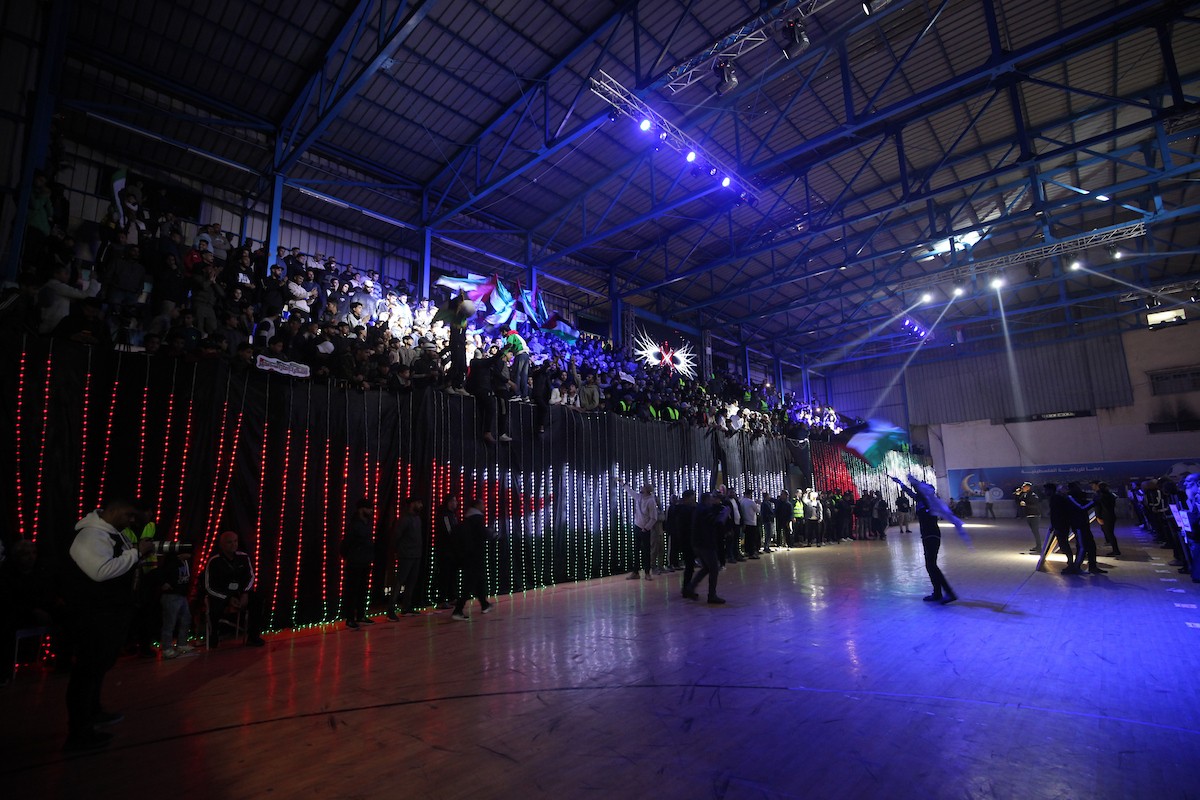 لاعبون فلسطينيون من فريقي النصيرات ورفح يتنافسون خلال مباراة كرة قدم على ملعب نادي خدمات النصيرات، ضمن بطولة غزة الرمضانية، بحضور حشد جماهيري كبير، في مخيم النصيرات بوسط قطاع غزة، بتاريخ 21 فبراير/شباط 2026. تصوير: معز صالحي / apaimages