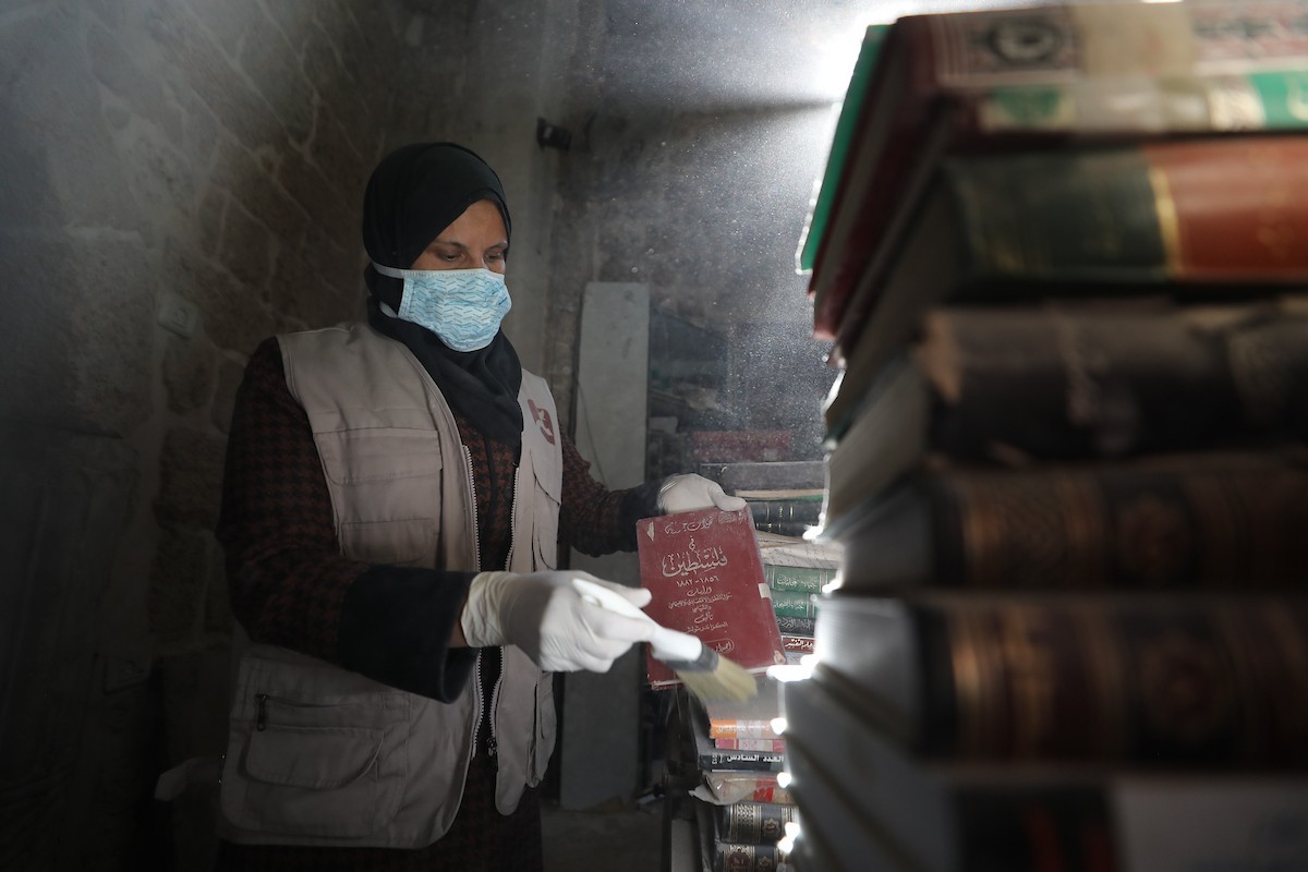 عملية الإنقاذ والترميم الأولية للكتب والمخطوطات بمكتبة الجامع العمري الكبير في البلدة القديمة بمدينة غزة في 2 مارس/آذار 2026.صورة: عمر أشتوي