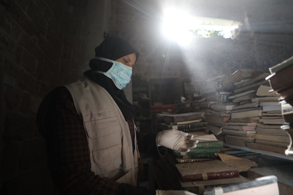 عملية الإنقاذ والترميم الأولية للكتب والمخطوطات بمكتبة الجامع العمري الكبير في البلدة القديمة بمدينة غزة في 2 مارس/آذار 2026.صورة: عمر أشتوي