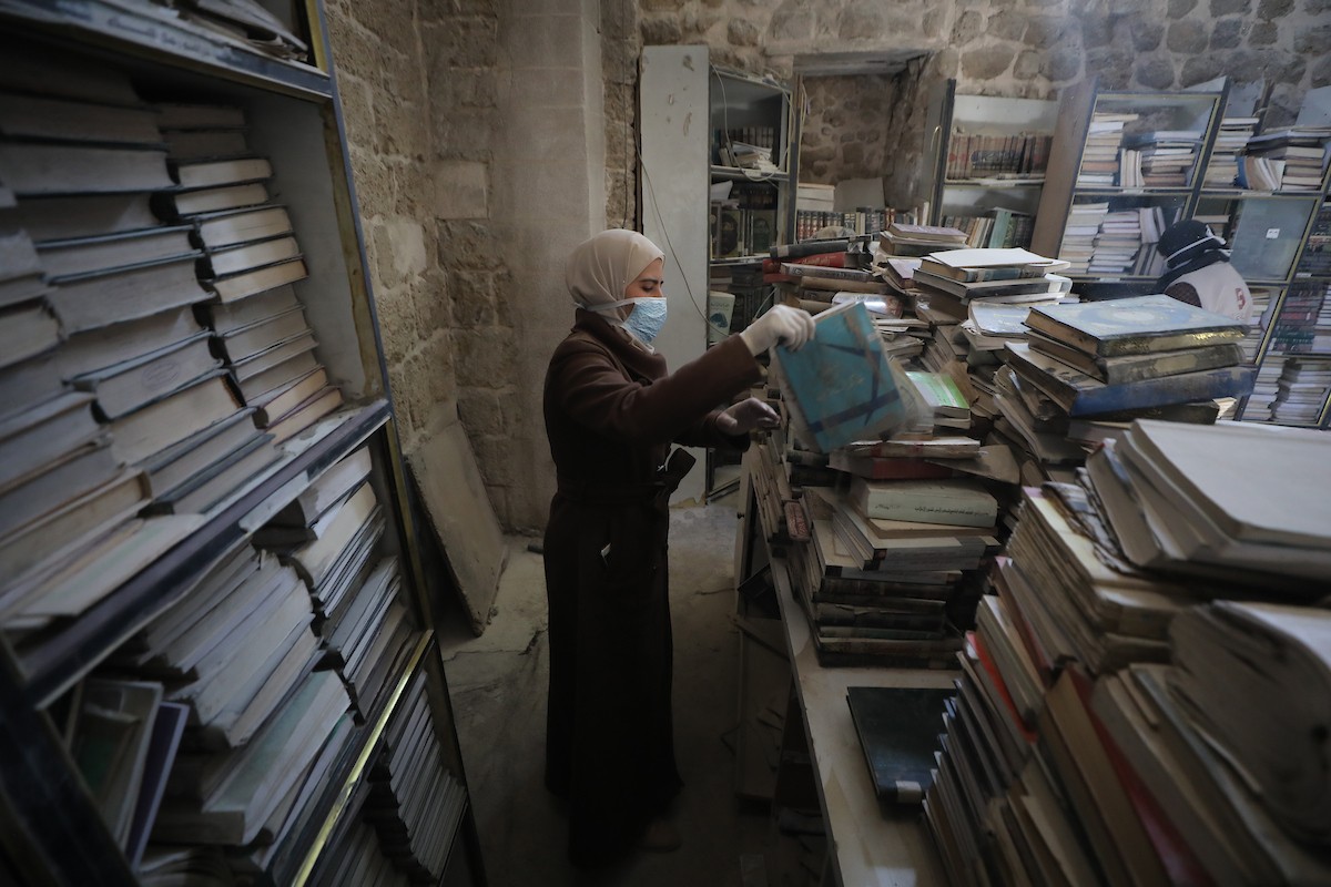 عملية الإنقاذ والترميم الأولية للكتب والمخطوطات بمكتبة الجامع العمري الكبير في البلدة القديمة بمدينة غزة في 2 مارس/آذار 2026.صورة: عمر أشتوي