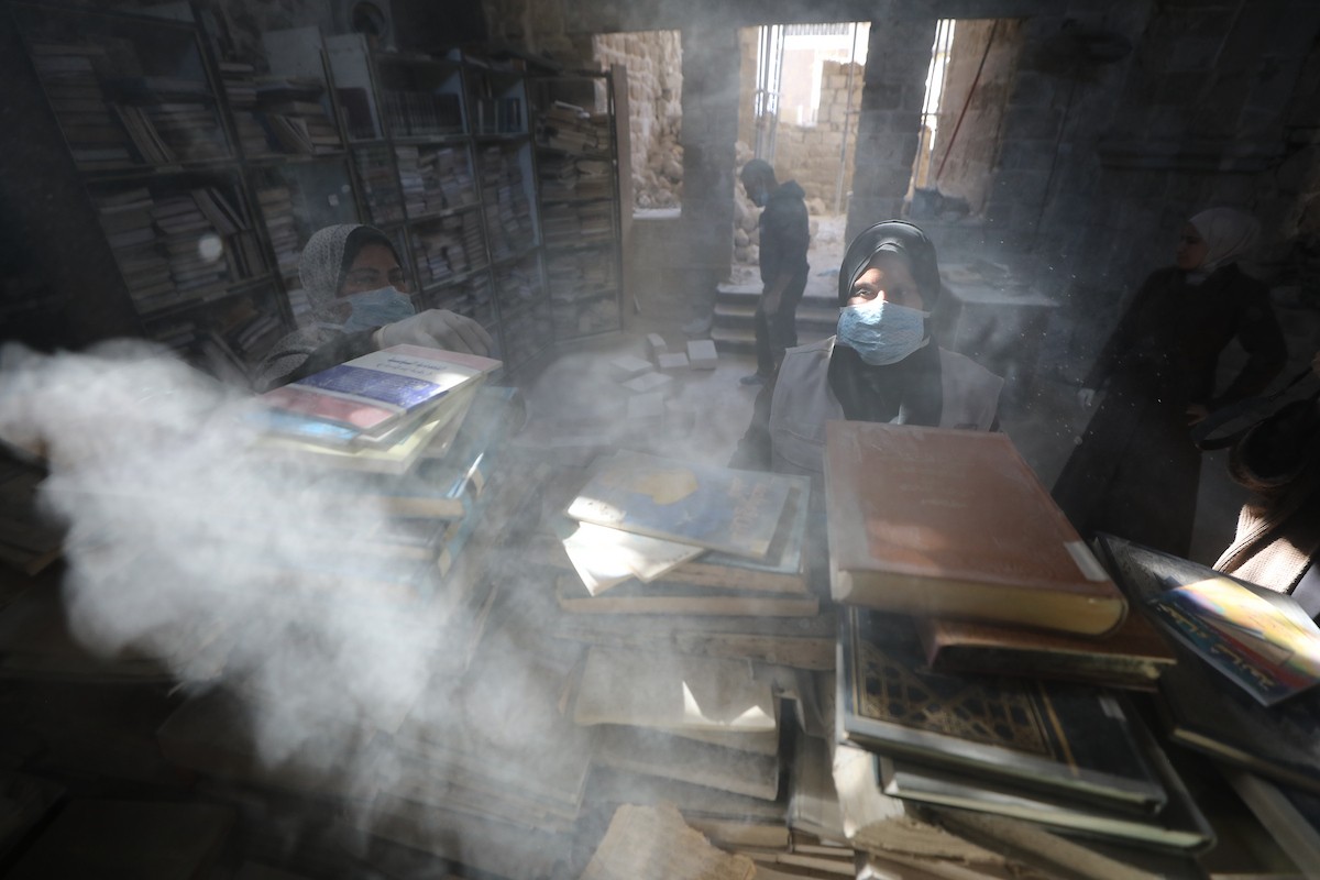 عملية الإنقاذ والترميم الأولية للكتب والمخطوطات بمكتبة الجامع العمري الكبير في البلدة القديمة بمدينة غزة في 2 مارس/آذار 2026.صورة: عمر أشتوي