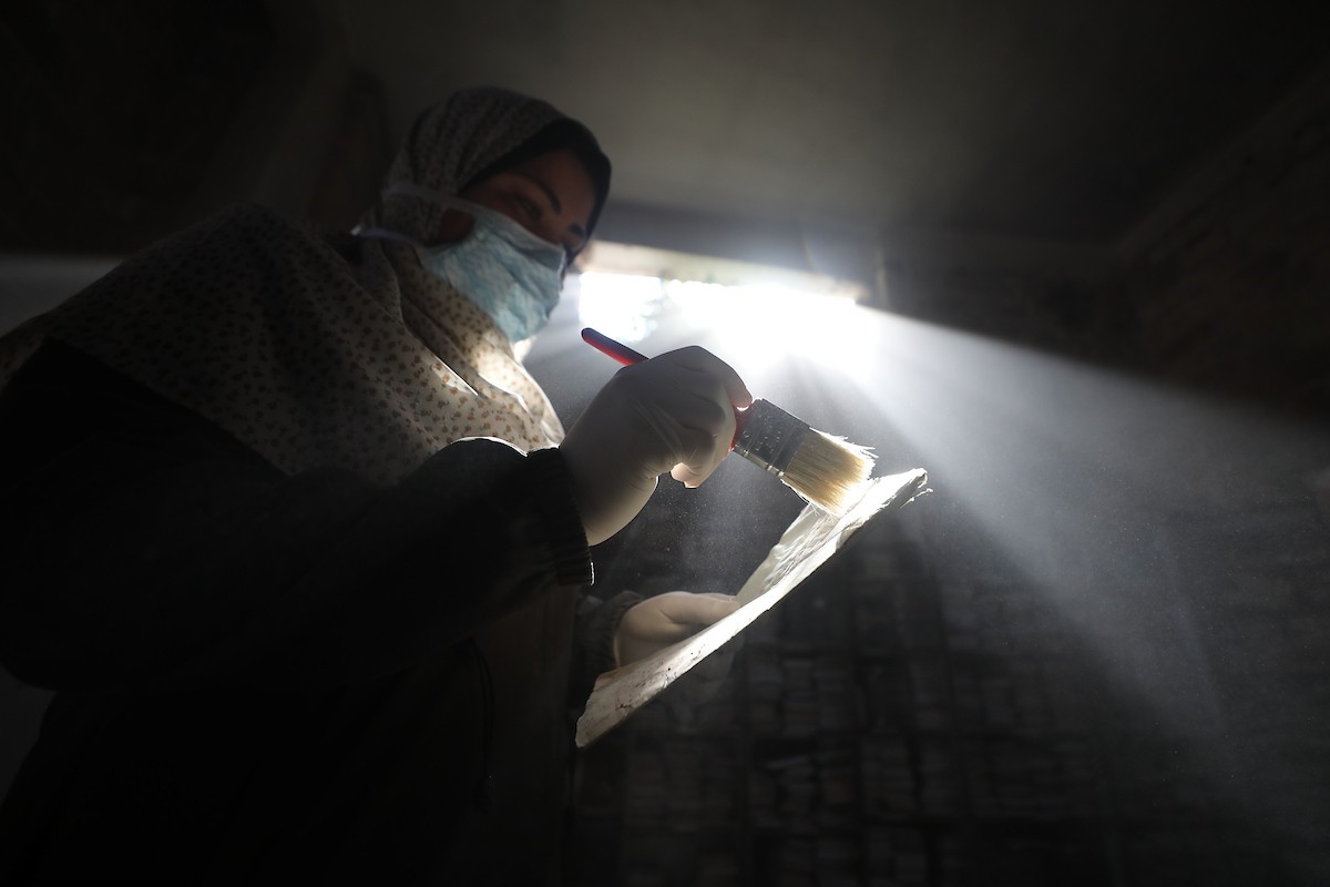 عملية الإنقاذ والترميم الأولية للكتب والمخطوطات بمكتبة الجامع العمري الكبير في البلدة القديمة بمدينة غزة في 2 مارس/آذار 2026.صورة: عمر أشتوي