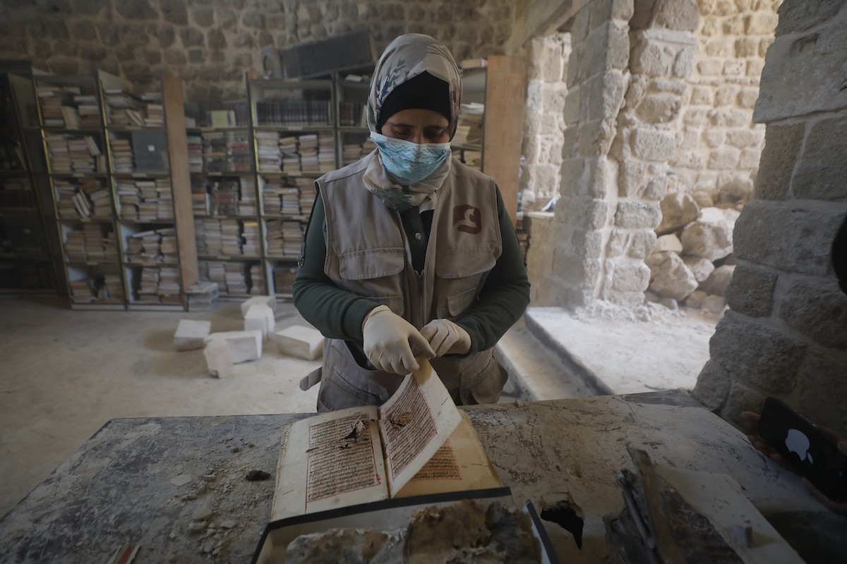 عملية الإنقاذ والترميم الأولية للكتب والمخطوطات بمكتبة الجامع العمري الكبير في البلدة القديمة بمدينة غزة في 2 مارس/آذار 2026.صورة: عمر أشتوي