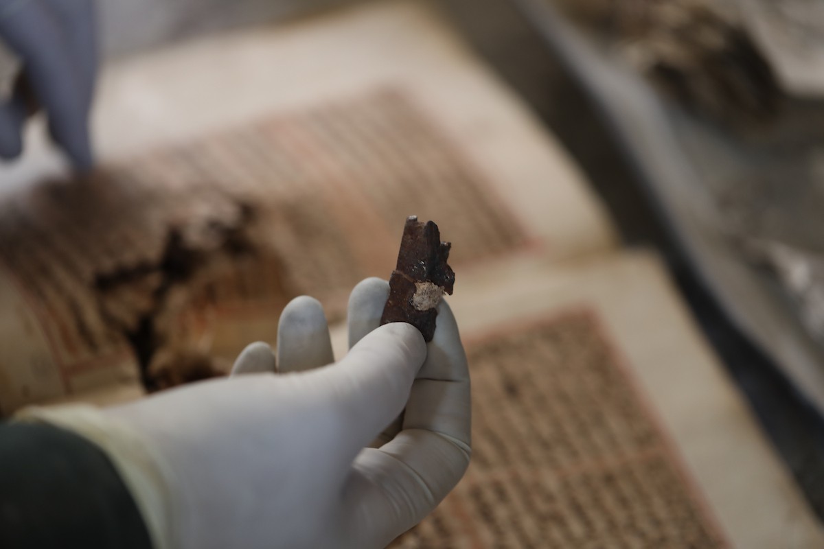 عملية الإنقاذ والترميم الأولية للكتب والمخطوطات بمكتبة الجامع العمري الكبير في البلدة القديمة بمدينة غزة في 2 مارس/آذار 2026.صورة: عمر أشتوي