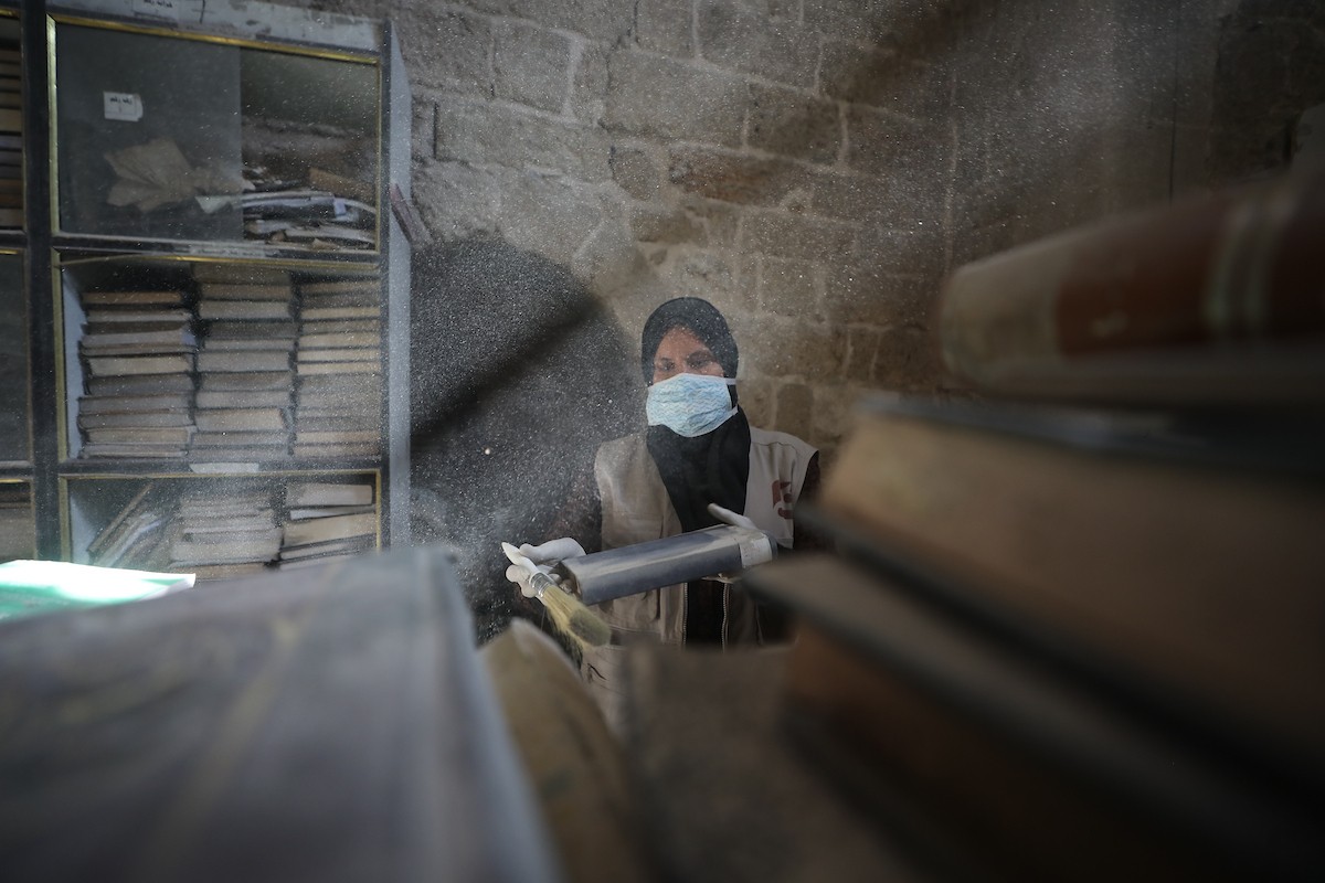 عملية الإنقاذ والترميم الأولية للكتب والمخطوطات بمكتبة الجامع العمري الكبير في البلدة القديمة بمدينة غزة في 2 مارس/آذار 2026.صورة: عمر أشتوي