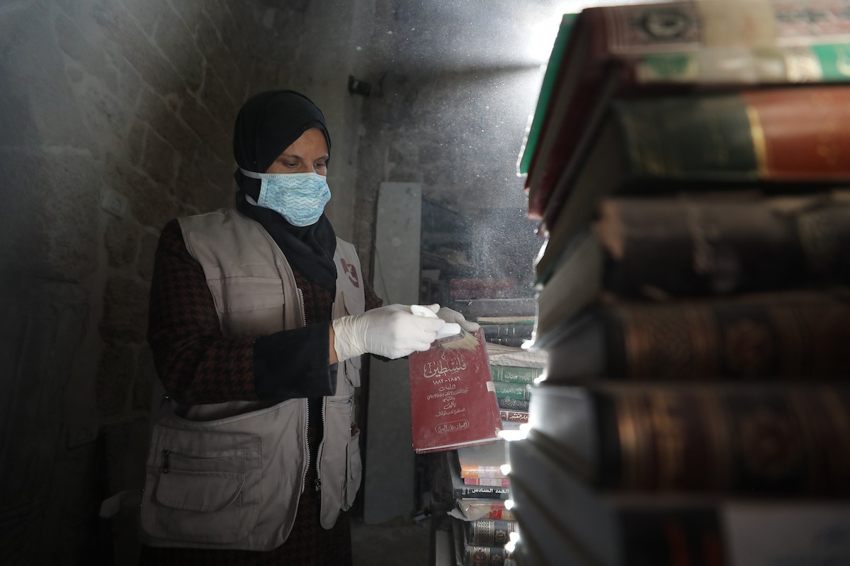 عملية الإنقاذ والترميم الأولية للكتب والمخطوطات بمكتبة الجامع العمري الكبير في البلدة القديمة بمدينة غزة في 2 مارس/آذار 2026.صورة: عمر أشتوي