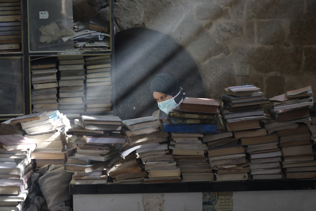 عملية الإنقاذ والترميم الأولية للكتب والمخطوطات بمكتبة الجامع العمري الكبير في البلدة القديمة بمدينة غزة في 2 مارس/آذار 2026.صورة: عمر أشتوي