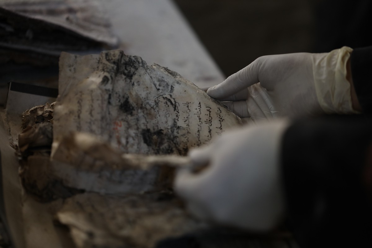 عملية الإنقاذ والترميم الأولية للكتب والمخطوطات بمكتبة الجامع العمري الكبير في البلدة القديمة بمدينة غزة في 2 مارس/آذار 2026.صورة: عمر أشتوي