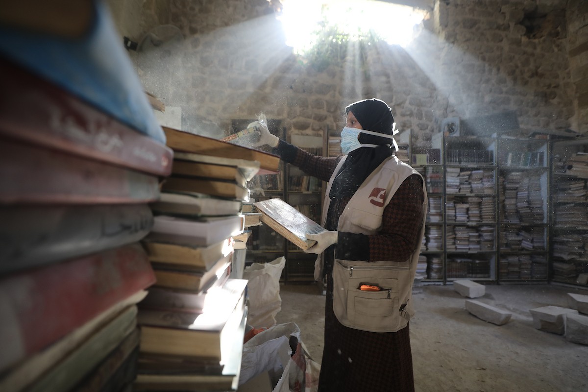 عملية الإنقاذ والترميم الأولية للكتب والمخطوطات بمكتبة الجامع العمري الكبير في البلدة القديمة بمدينة غزة في 2 مارس/آذار 2026.صورة: عمر أشتوي