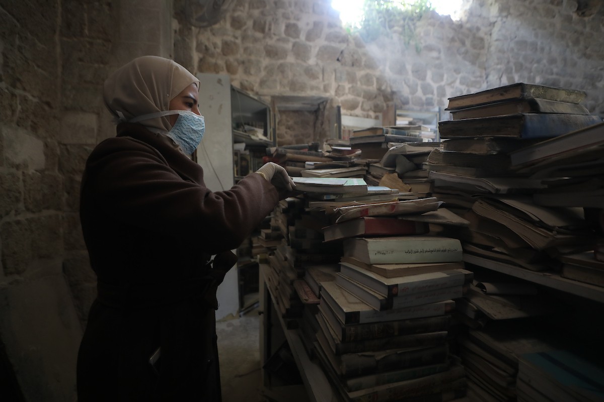 عملية الإنقاذ والترميم الأولية للكتب والمخطوطات بمكتبة الجامع العمري الكبير في البلدة القديمة بمدينة غزة في 2 مارس/آذار 2026.صورة: عمر أشتوي