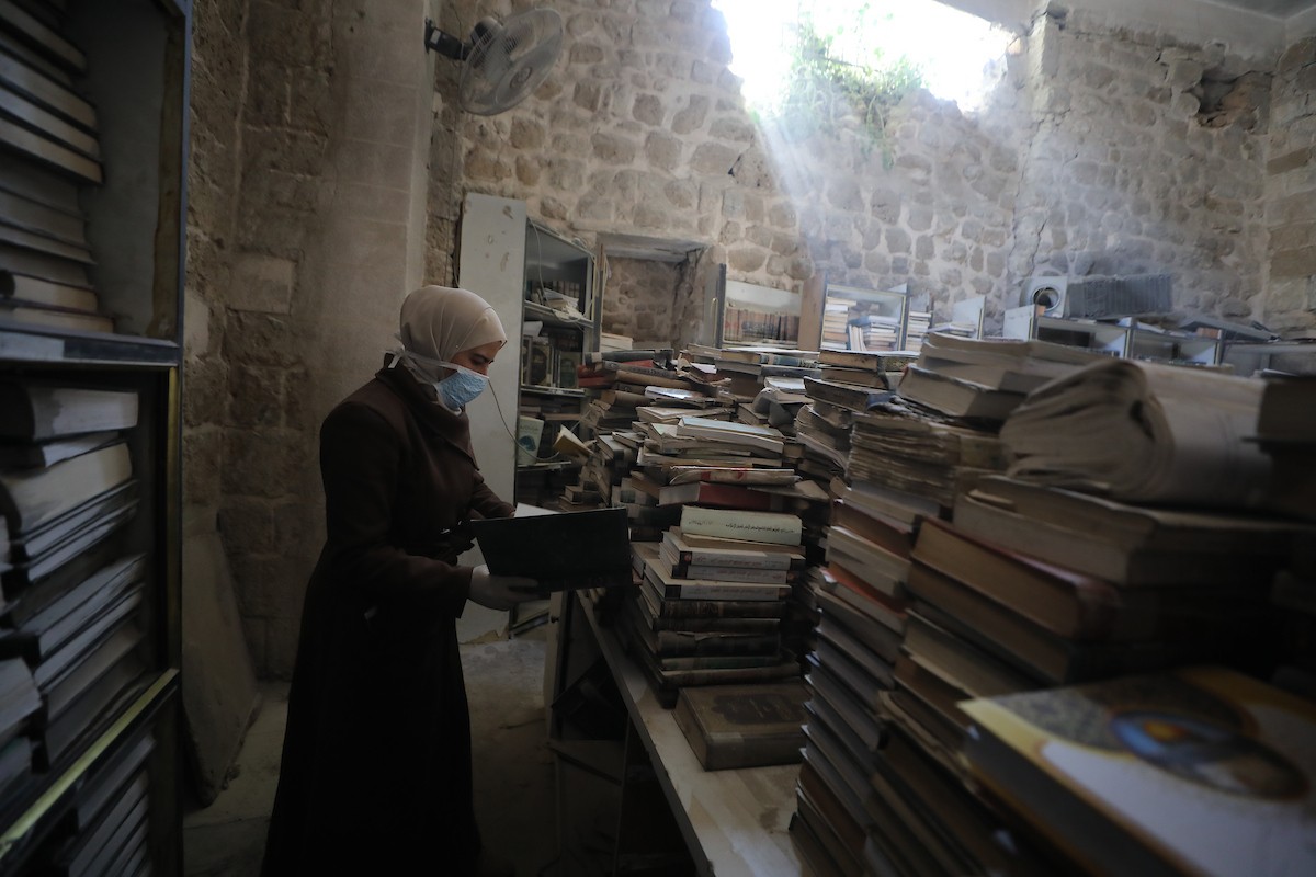 عملية الإنقاذ والترميم الأولية للكتب والمخطوطات بمكتبة الجامع العمري الكبير في البلدة القديمة بمدينة غزة في 2 مارس/آذار 2026.صورة: عمر أشتوي