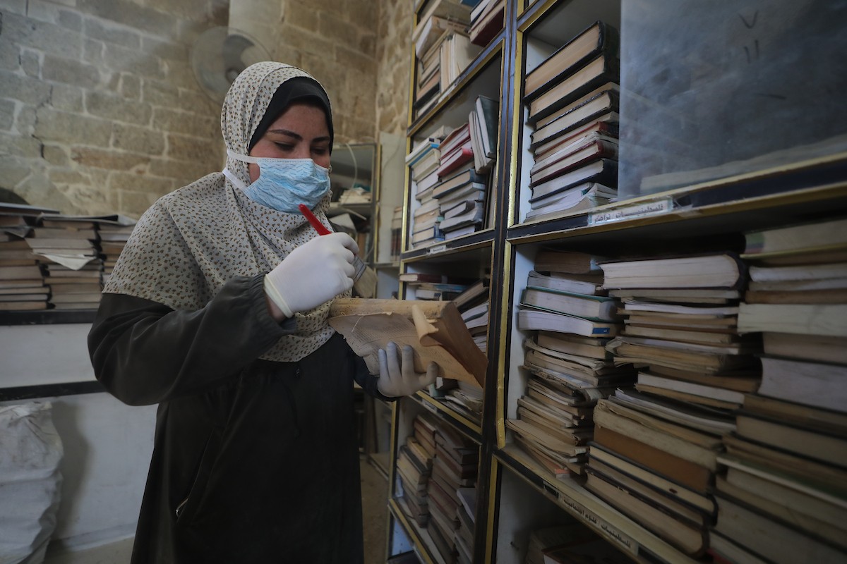 عملية الإنقاذ والترميم الأولية للكتب والمخطوطات بمكتبة الجامع العمري الكبير في البلدة القديمة بمدينة غزة في 2 مارس/آذار 2026.صورة: عمر أشتوي