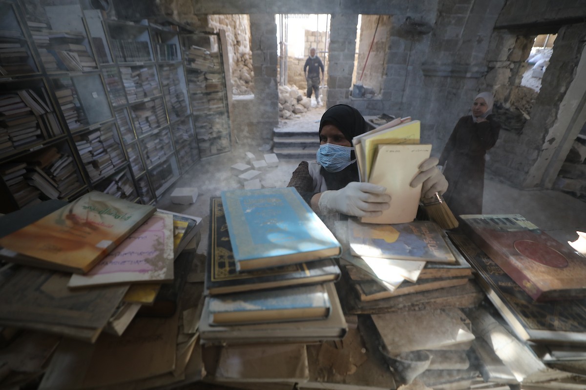 عملية الإنقاذ والترميم الأولية للكتب والمخطوطات بمكتبة الجامع العمري الكبير في البلدة القديمة بمدينة غزة في 2 مارس/آذار 2026.صورة: عمر أشتوي