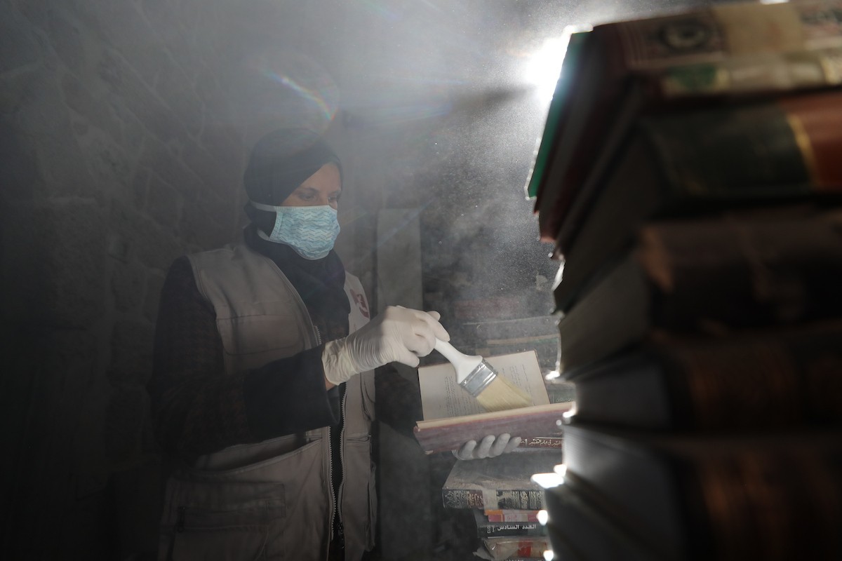 عملية الإنقاذ والترميم الأولية للكتب والمخطوطات بمكتبة الجامع العمري الكبير في البلدة القديمة بمدينة غزة في 2 مارس/آذار 2026.صورة: عمر أشتوي