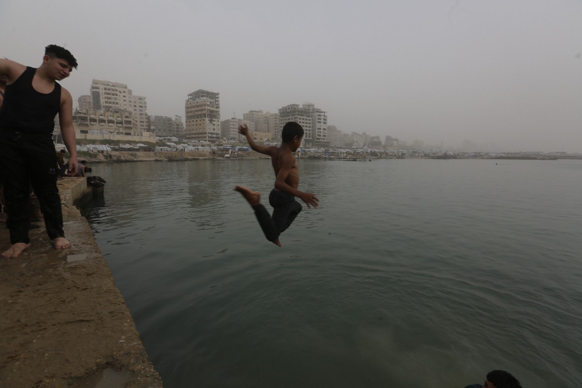 يقضي أطفال فلسطينيون أوقاتهم على شاطئ  غزة، باحثين عن ملاذ من حرارة الشمس وضغوط الحياة اليومية، في ظلّ الظروف الإنسانية المتردية التي يواجهها سكان القطاع جراء الحرب الدائرة، 17 أبريل/نيسان 2026. تصوير: بلال أسامة
