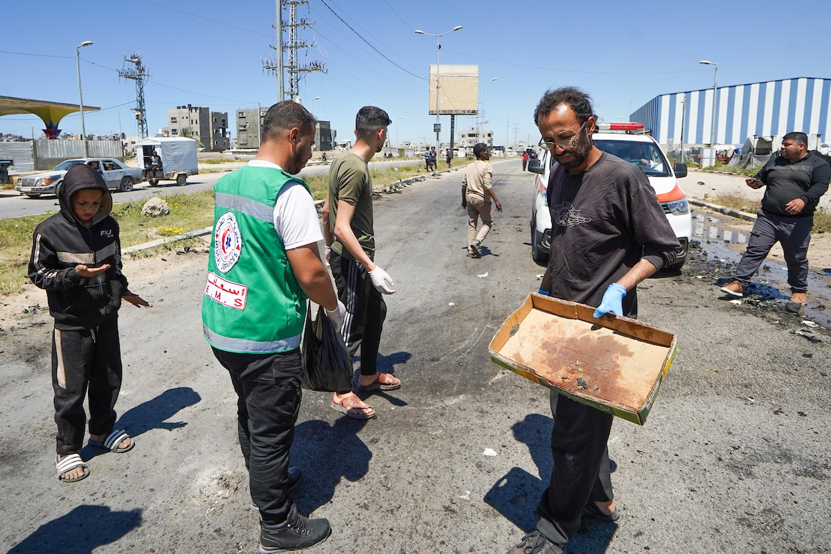 فلسطينيون يتفقدون سيارة مدنية مدمرة بعد استهدافها في غارة جوية إسرائيلية أسفرت عن مقتل ثلاثة أشخاص في شارع صلاح الدين، جنوب مخيم البريج للاجئين وسط قطاع غزة، 23 أبريل/نيسان 2026. صورة: رمزي أبو عامر