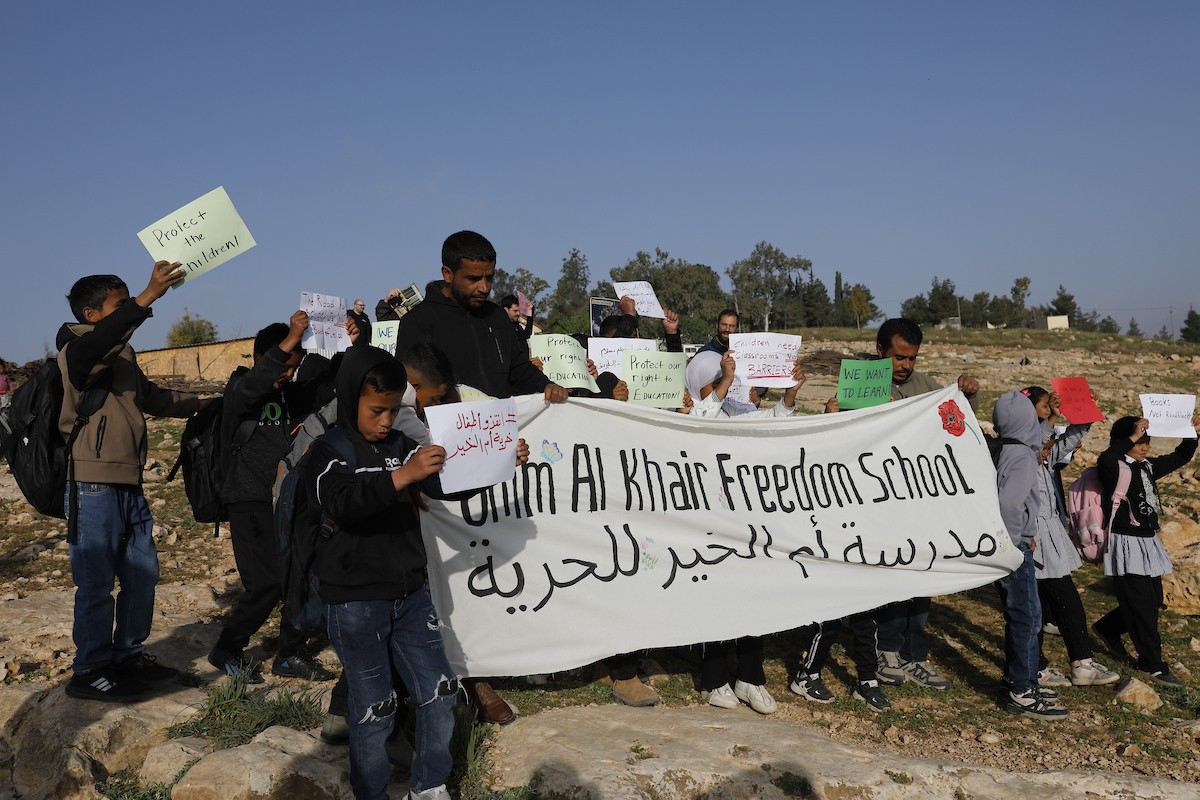 الخليل - أطفال خربة أم الخير وبمشاركة نشطاء سلام دوليين ينظمون وقفة سلمية احتجاجا على إغلاق الجيش الإسرائيلي للطريق الرئيسي المؤدي إلى مدارسهم منذ أسبوع، 19 أبريل/نيسان 2026. تصوير: مأمون وزواز