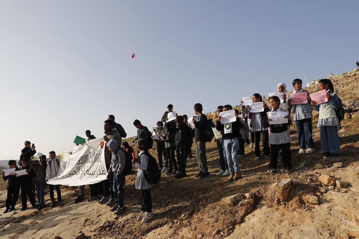 الخليل - أطفال خربة أم الخير وبمشاركة نشطاء سلام دوليين ينظمون وقفة سلمية احتجاجا على إغلاق الجيش الإسرائيلي للطريق الرئيسي المؤدي إلى مدارسهم منذ أسبوع، 19 أبريل/نيسان 2026. تصوير: مأمون وزواز