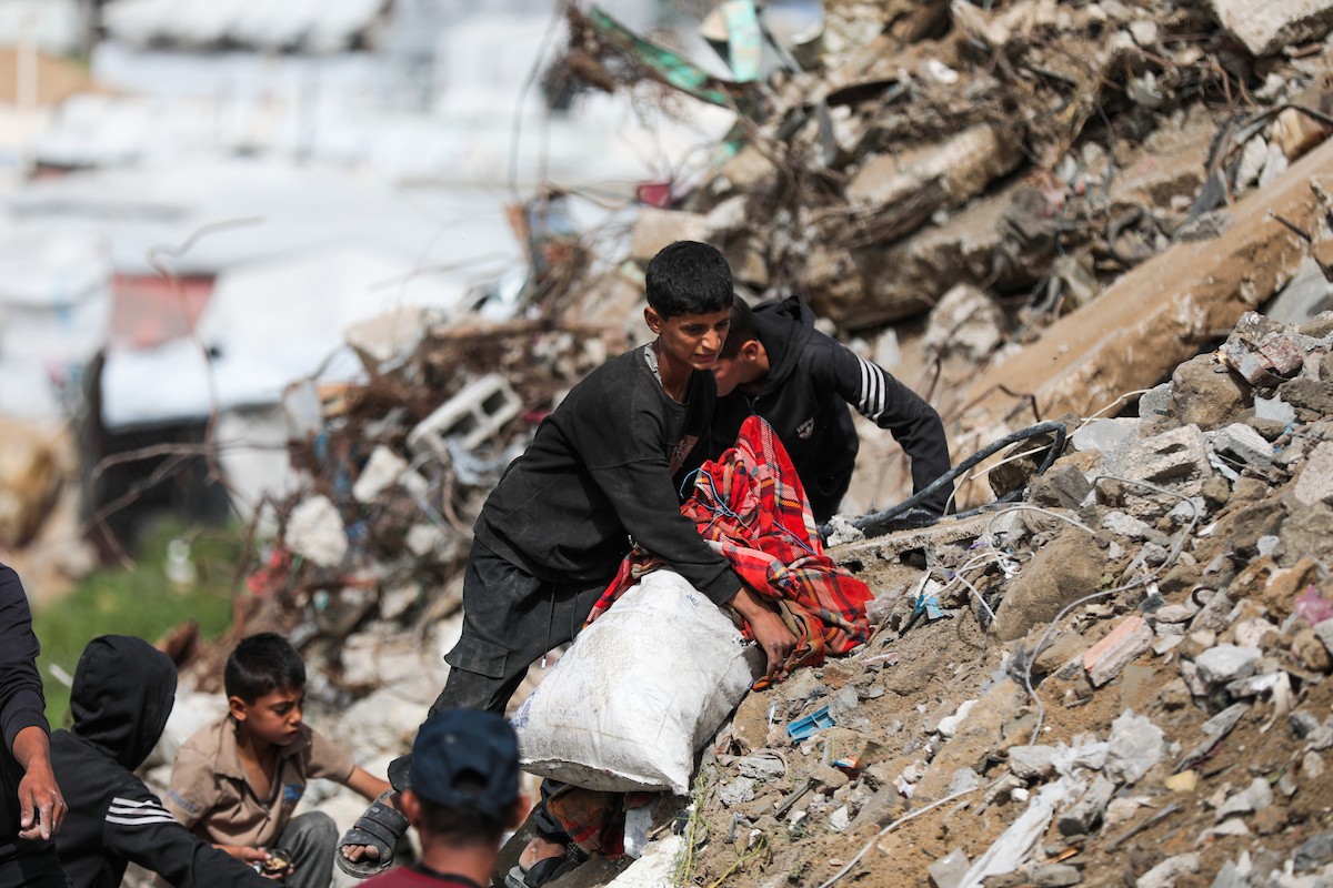أطفال فلسطينيون يبحثون بين أكوام القمامة عن بقايا الطعام أو الألعاب في مكب نفايات بمخيم البريج للاجئين وسط قطاع غزة، في 4 أبريل/نيسان 2026، بالتزامن مع يوم الطفل الفلسطيني.(صورة: رمزي أبو عامر)