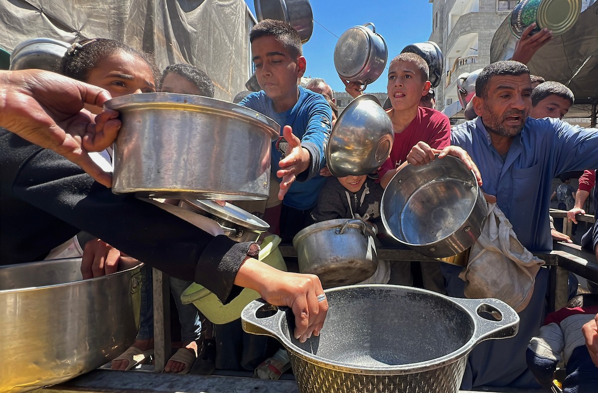 يتلقى فلسطينيون نازحون طعامًا من مطبخ خيري في مخيم النصيرات للاجئين وسط قطاع غزة، في 23 أبريل/نيسان 2026، (صورة: يوسف أبو وطفة)