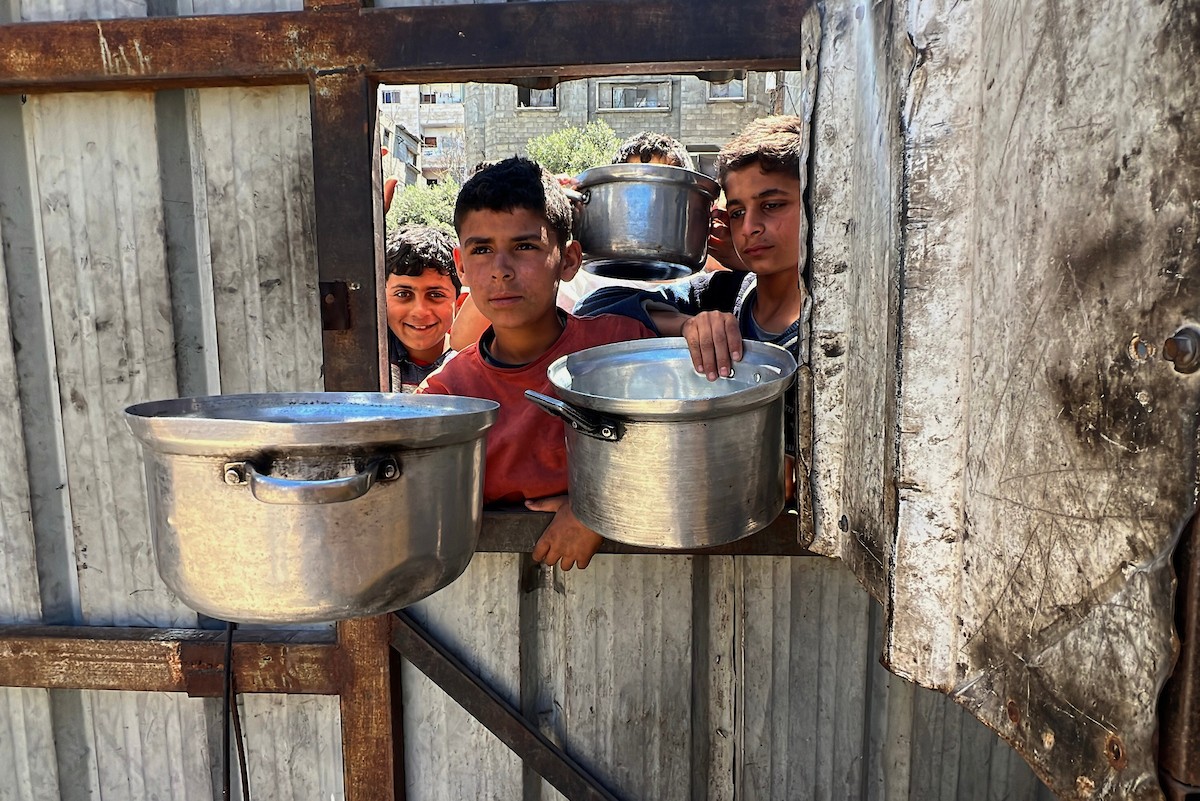 يتلقى فلسطينيون نازحون طعامًا من مطبخ خيري في مخيم النصيرات للاجئين وسط قطاع غزة، في 23 أبريل/نيسان 2026، (صورة: يوسف أبو وطفة)
