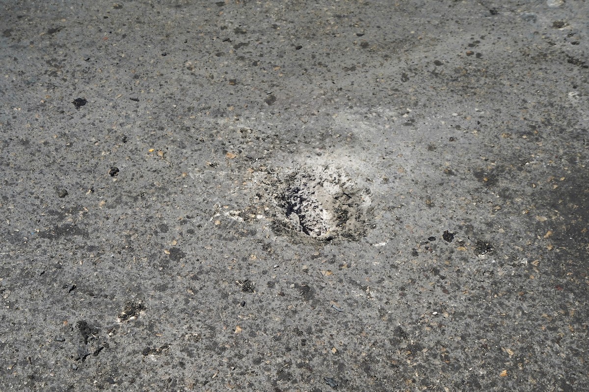 فلسطينيون يتفقدون سيارة مدنية مدمرة بعد استهدافها في غارة جوية إسرائيلية أسفرت عن مقتل ثلاثة أشخاص في شارع صلاح الدين، جنوب مخيم البريج للاجئين وسط قطاع غزة، 23 أبريل/نيسان 2026. صورة: رمزي أبو عامر