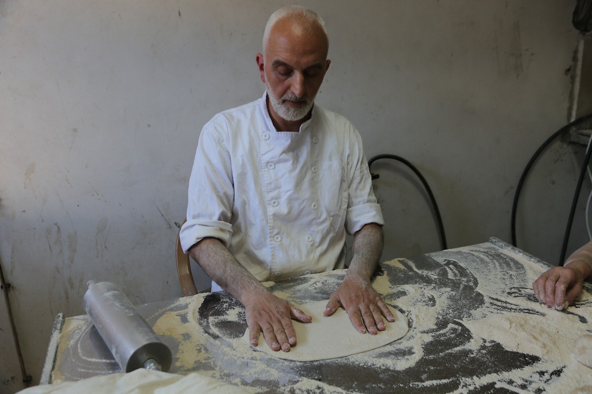 في 29 أبريل/نيسان 2026، عائلات سامرية تُعد خبز طري لطقوس ذبح الأضاحي في عيد الفصح على جبل جرزيم، المطل على مدينة نابلس في الضفة الغربية. ويعيش نحو 700 سامري بين مدينة نابلس في الضفة الغربية ومدينة حولون جنوب تل أبيب. (صورة: محمد ناصر)