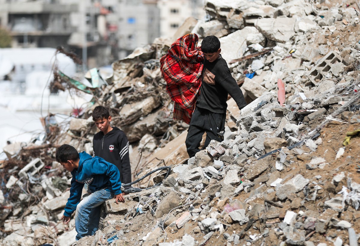 أطفال فلسطينيون يبحثون بين أكوام القمامة عن بقايا الطعام أو الألعاب في مكب نفايات بمخيم البريج للاجئين وسط قطاع غزة، في 4 أبريل/نيسان 2026، بالتزامن مع يوم الطفل الفلسطيني.(صورة: رمزي أبو عامر)