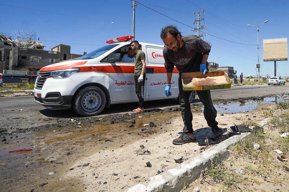 فلسطينيون يتفقدون سيارة مدنية مدمرة بعد استهدافها في غارة جوية إسرائيلية أسفرت عن مقتل ثلاثة أشخاص في شارع صلاح الدين، جنوب مخيم البريج للاجئين وسط قطاع غزة، 23 أبريل/نيسان 2026. صورة: رمزي أبو عامر