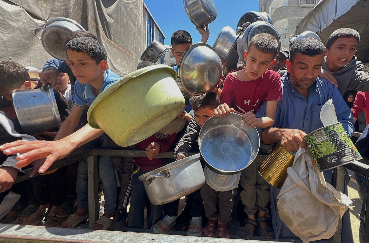 يتلقى فلسطينيون نازحون طعامًا من مطبخ خيري في مخيم النصيرات للاجئين وسط قطاع غزة، في 23 أبريل/نيسان 2026، (صورة: يوسف أبو وطفة)