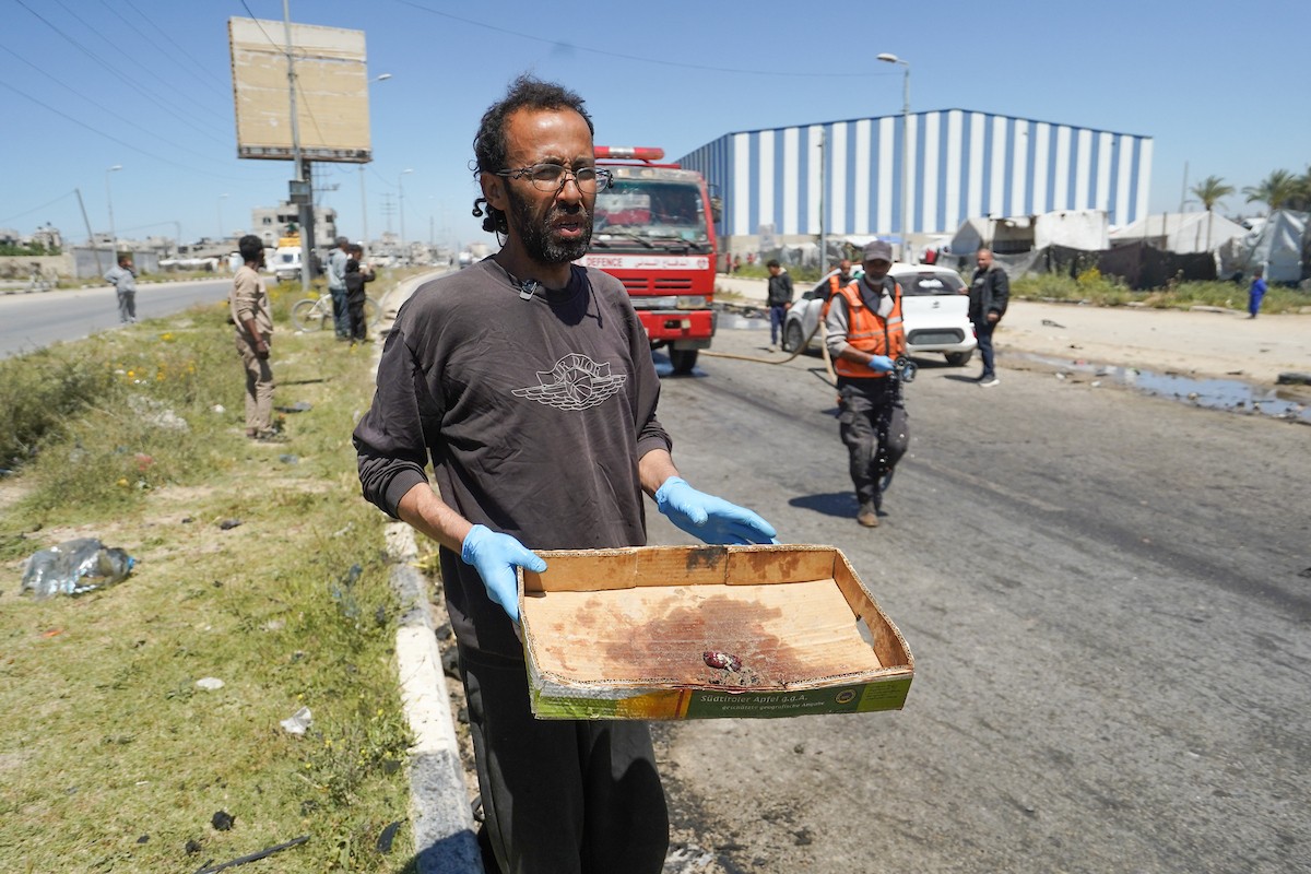 فلسطينيون يتفقدون سيارة مدنية مدمرة بعد استهدافها في غارة جوية إسرائيلية أسفرت عن مقتل ثلاثة أشخاص في شارع صلاح الدين، جنوب مخيم البريج للاجئين وسط قطاع غزة، 23 أبريل/نيسان 2026. صورة: رمزي أبو عامر