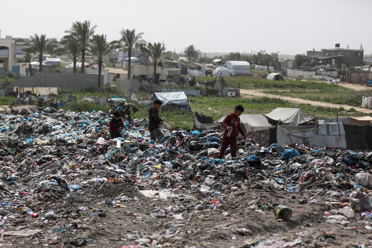 أطفال فلسطينيون يبحثون بين أكوام القمامة عن بقايا الطعام أو الألعاب في مكب نفايات بمخيم البريج للاجئين وسط قطاع غزة، في 4 أبريل/نيسان 2026، بالتزامن مع يوم الطفل الفلسطيني.(صورة: رمزي أبو عامر)