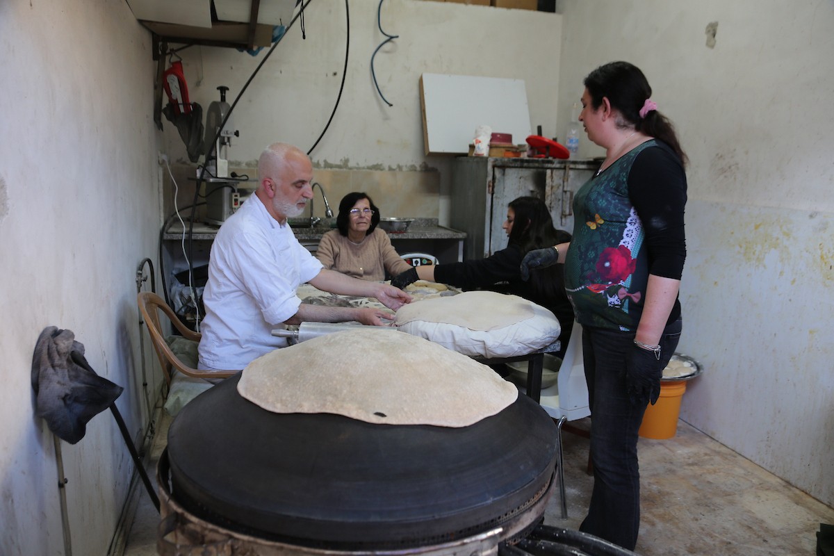 في 29 أبريل/نيسان 2026، عائلات سامرية تُعد خبز طري لطقوس ذبح الأضاحي في عيد الفصح على جبل جرزيم، المطل على مدينة نابلس في الضفة الغربية. ويعيش نحو 700 سامري بين مدينة نابلس في الضفة الغربية ومدينة حولون جنوب تل أبيب. (صورة: محمد ناصر)