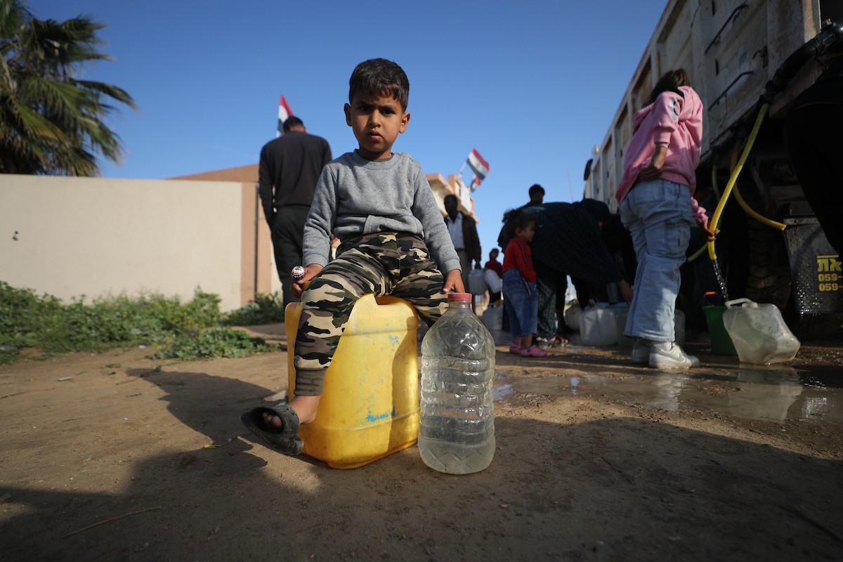 يتجمع الفلسطينيون النازحون لجلب الماء وسط خيام متداعية، ما يعكس تدهور الأوضاع المعيشية والنقص الحاد في الاحتياجات الأساسية، مخيم النصيرات للاجئين وسط قطاع غزة، 31 مارس/آذار 2026. تصوير: حسن الجديدي